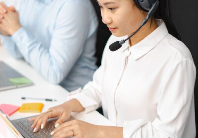 Customer service representatives wearing headsets at their desks