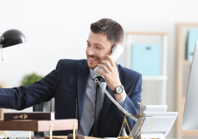 Businessman answering a desk phone in an office