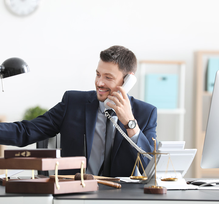 Businessman answering a desk phone in an office